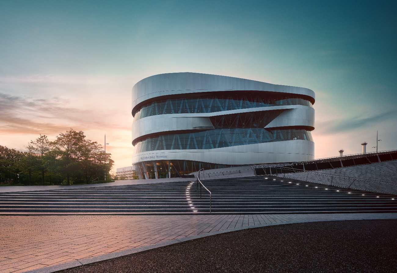 Hügel vor dem Mercedes-Benz Museum bei Abendanbruch mit Museum im Hintergrund.